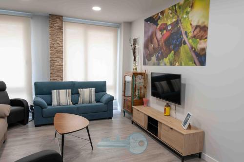 a living room with a blue couch and a tv at EDIFICIO 1521 in Logroño