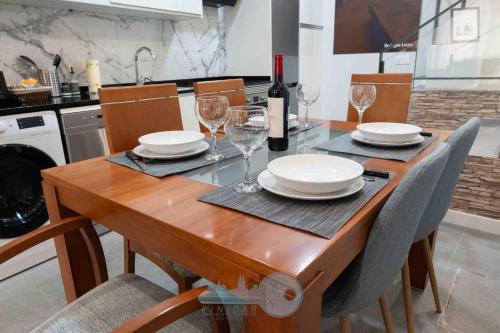 a wooden table with plates and wine glasses on it at EDIFICIO 1521 in Logroño