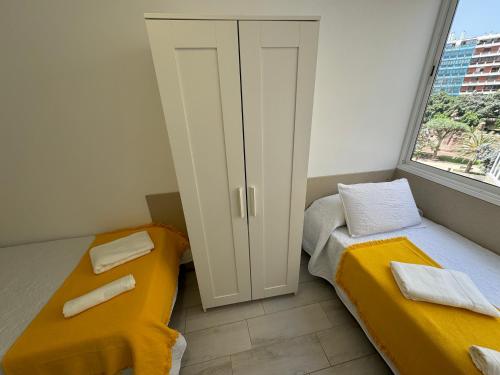 a small room with two beds and a window at Vistas Plaza España centro ciudad Las Palmas in Las Palmas de Gran Canaria