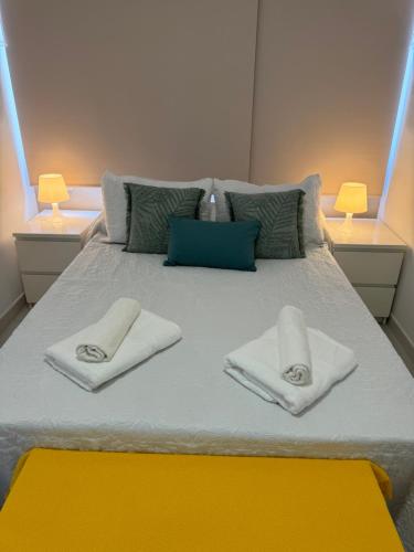 a bed with two towels and two lamps on it at Vistas Plaza España centro ciudad Las Palmas in Las Palmas de Gran Canaria
