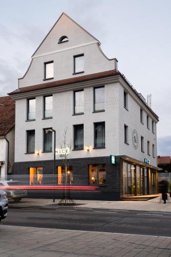 a large white building on the corner of a street at Hotel Nice in Laupheim