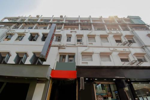 Calcutta Bara BazarにあるHotel O Lindsay Inn Guest Houseの正面に店がある背の高い白い建物