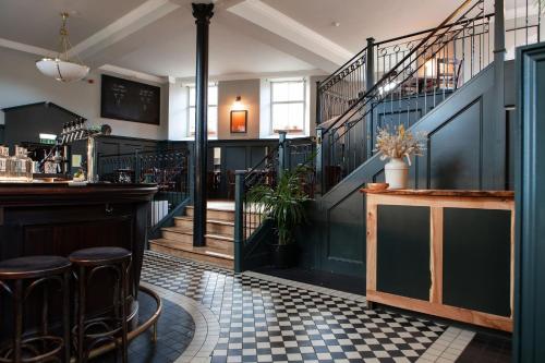 a bar with stools in a room with stairs at Celentano's Restaurant with Rooms in Glasgow
