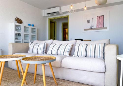 a living room with a white couch and two tables at Apartment Vicente in Vilanova i la Geltrú