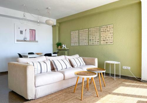 a living room with a white couch and two tables at Apartment Vicente in Vilanova i la Geltrú
