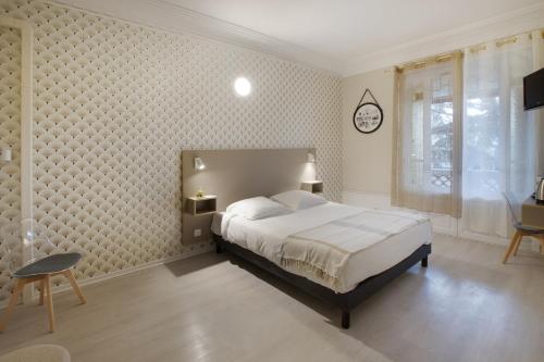 a bedroom with a bed and a clock on the wall at GAB HOUSE - Lyon Bron - Eurexpo City Living Stay in Bron
