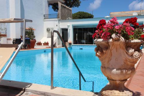 a vase filled with flowers next to a swimming pool at Hotel Lord Byron in Ischia