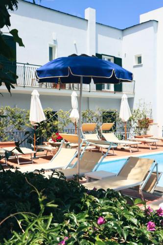 a group of chairs and an umbrella next to a pool at Hotel Lord Byron in Ischia