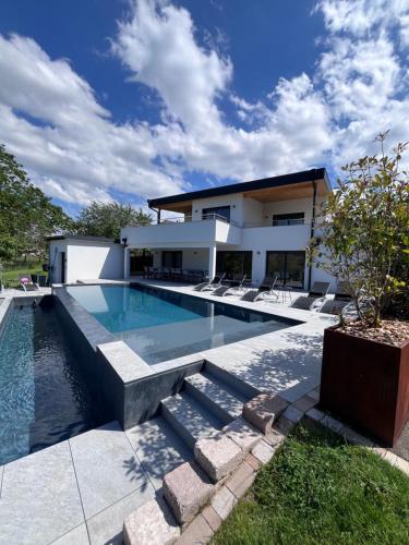 une piscine devant une maison dans l'établissement Villa privée 230m2/ Piscine débordement/Billard-Babyfoot-Boulodrome-Flipper/Strasbourg, à Dettwiller