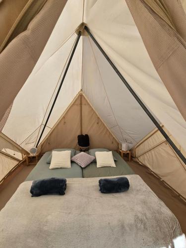 a tent with two pillows on a bed in it at Au coeur des plantations in La Possession