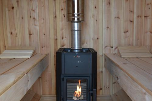 a stove in a room with wooden walls at Het Toppunt groot vakantiehuis aan het water in Sneek