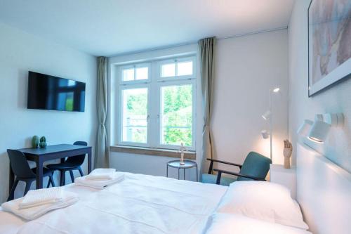 a bedroom with a bed and a desk and a window at HITrental Riesbach Apartments in Zürich