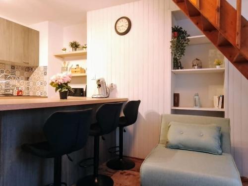 une cuisine avec un canapé et un bar avec une horloge dans l'établissement Superbe T2 avec Terrasse, à Montpellier