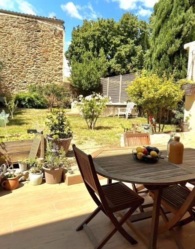 une table et des chaises en bois sur une terrasse dans l'établissement La Pause Bonheur - La Vagabonde, à Luc-sur-Orbieu
