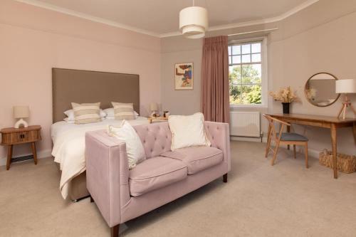 a bedroom with a bed and a couch and a table at Celentano's Restaurant with Rooms in Glasgow