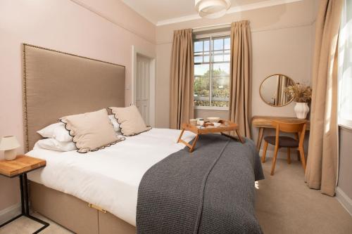 a bedroom with a bed and a desk and a window at Celentano's Restaurant with Rooms in Glasgow