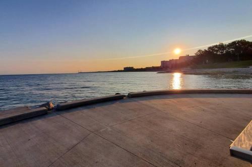 a sunset over a body of water with a boat at Cozy Bungalow 10 Min to DTWN CLE in Euclid