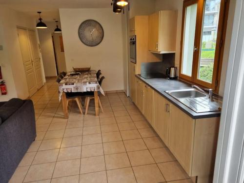 une cuisine avec une table et un évier ainsi qu'une cuisine avec un canapé dans l'établissement Appartement familial en résidence Saint Gervais les bains, à Saint-Gervais-les-Bains