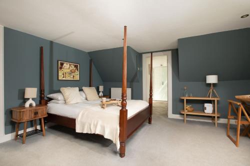 a bedroom with a canopy bed and blue walls at Celentano's Restaurant with Rooms in Glasgow