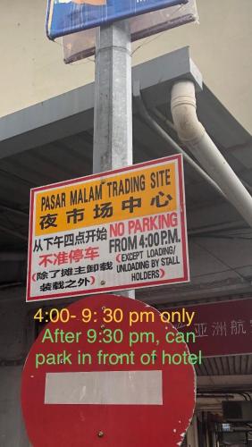 a sign on a pole with a parking sign at City hotel in Sibu
