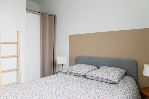 une chambre avec un lit avec deux oreillers dessus dans l'établissement Appartement F3 55m2 à 5' de Paris, à Ivry-sur-Seine