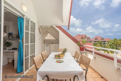 a dining room with a table and chairs on a balcony at Appartement Madinina 6 personnes vue sur mer dans village vacances in Sainte-Luce
