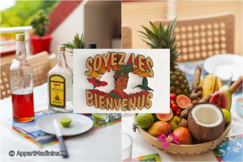 a table with a bowl of fruit and a bottle of wine at Appartement Madinina 6 personnes vue sur mer dans village vacances in Sainte-Luce