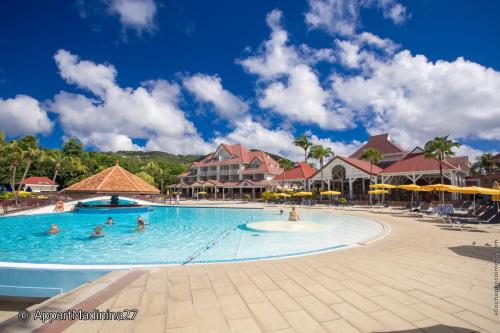 a group of people in a swimming pool at a resort at Appartement Madinina 6 personnes vue sur mer dans village vacances in Sainte-Luce