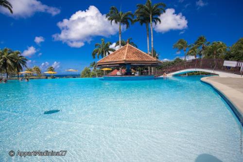 a large pool at a resort with a gazebo at Appartement Madinina 6 personnes vue sur mer dans village vacances in Sainte-Luce