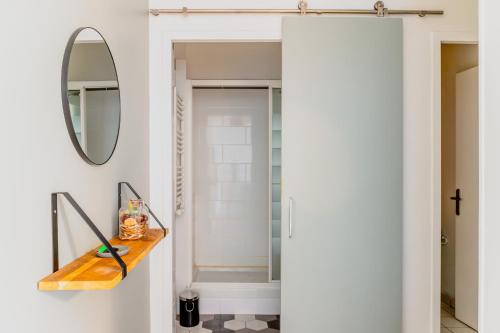 La salle de bains est pourvue d'un miroir et d'une douche à l'italienne. dans l'établissement Appartement F3 55m2 à 5' de Paris, à Ivry-sur-Seine