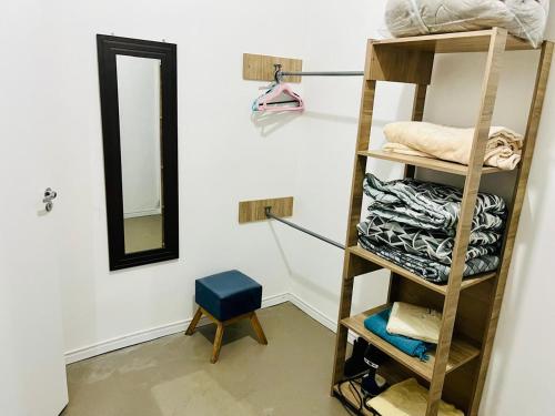 Cette chambre comprend une étagère avec des serviettes et un miroir. dans l'établissement Chalé Vista Linda, à Campos do Jordão