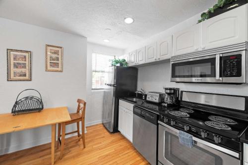a kitchen with black appliances and a wooden table at Panoramic Views on Your Front Porch in Pittsburgh