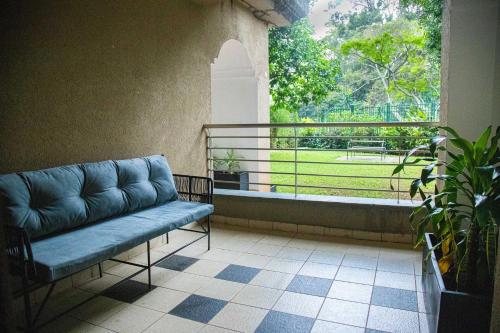 a couch sitting in a room with a window at Lion Villas in Nairobi