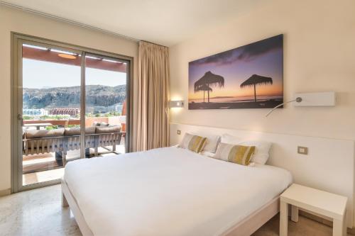 pokój hotelowy z łóżkiem i dużym oknem w obiekcie Bahia - Adjona 2,3 PENTHOUSE SEA VIEW & JACUZZI 2B w mieście Palm-Mar