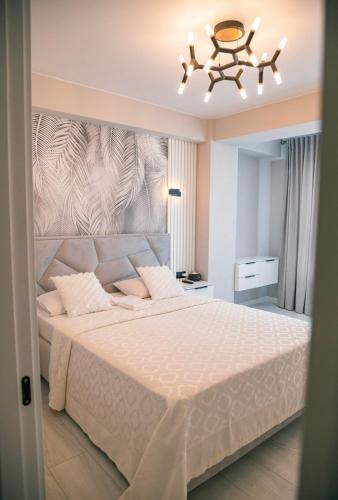 a bedroom with a large bed and a chandelier at Apartament Lux Burebista 114 in Chişinău