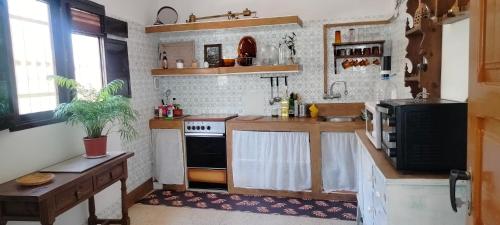 a kitchen with a sink and a stove top oven at Casa Cueva Rural Trébola, Artenara in Juncalillo
