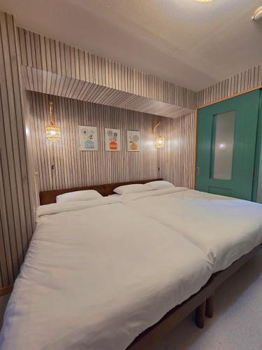 a large white bed in a small room at ueno minowa 602 in Tokyo