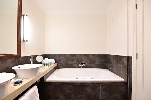 a bathroom with a large tub and a sink at Dolce CampoReal Lisboa in Turcifal
