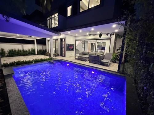 a large swimming pool in a house at night at Super Luxury 3 Bedroom Private Pool Villa with Jacuzzi, Near 711, 10 minutes to Walking Street and Pattaya Beach - MT6 in Pattaya