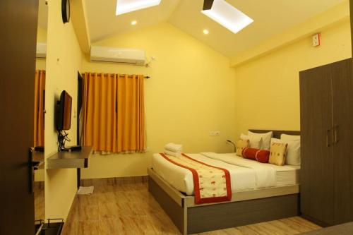 a bedroom with a bed and a television in it at Mohor Kutir Resorts in Bolpur