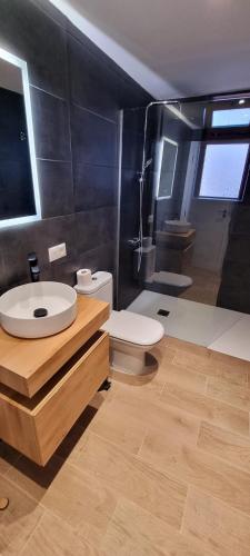 a bathroom with a white sink and a toilet at Casa Joy in Tejina de Isora