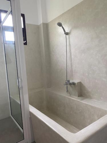 a bathroom with a bath tub with a shower at Ocean Crest Apartments in Mihiripenne