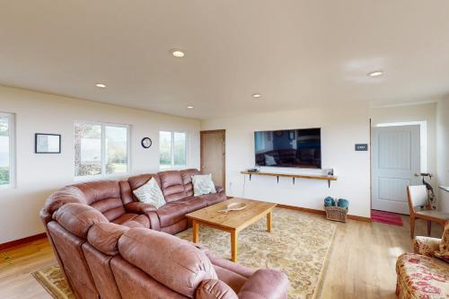 a living room with a couch and a table at Cape Satisfaction in Ilwaco