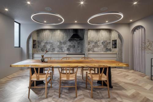 a dining room with a large wooden table and chairs at yado taniguchi in Matsuzaka