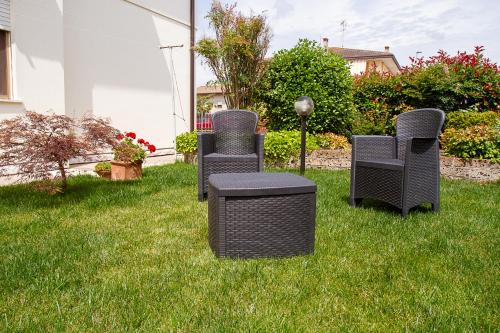 four wicker chairs and a table in the grass at Apartments Delise in Scardovari
