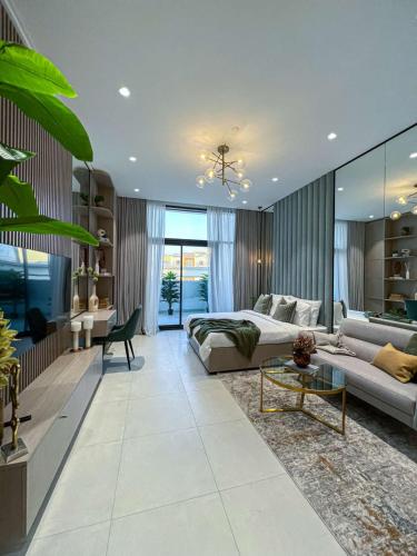 a living room with a bed and a couch at Bright New Studio with Pool & Gym Access, 5 min from Gardens Metro in Dubai
