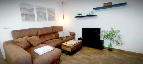 a living room with a brown couch and a table at Apartamento en la montaña, Serra in Serra