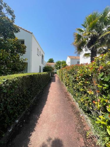 un chemin de terre devant un bâtiment blanc dans l'établissement Maison bord de mer, à Saint-Georges-de-Didonne