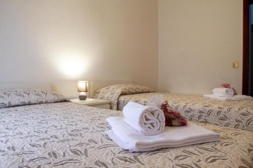 a hotel room with two beds with towels on them at Apartments Delise in Scardovari