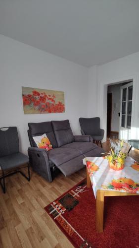 a living room with a couch and a table at Ferienwohnung Familie Schneider in Neustadt in Sachsen